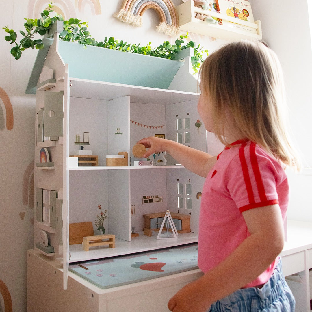 Child engaging with the Barnshenn wooden doll house, showcasing its charming interior design and educational play features